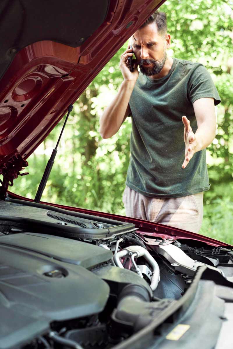 Junger Mann prüft Getriebeschaden bei Schrottauto Ankauf Idstein